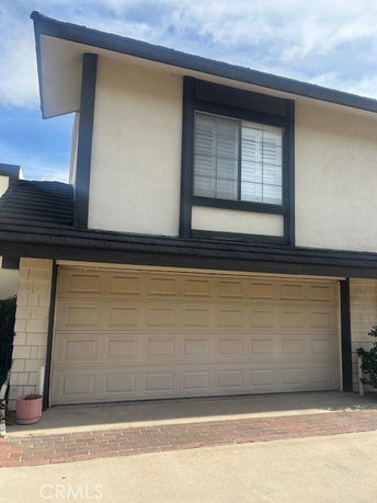 Front view of a house with a double garage and a window above.
