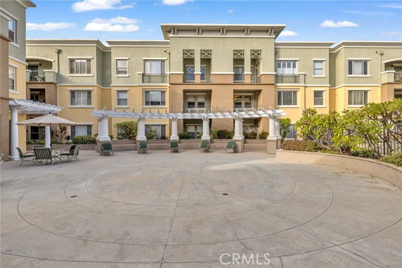 Front view of a multi-story building with large patio area.