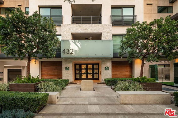 Front view of a multi-story building entrance with a modern facade and prominent number '432'.