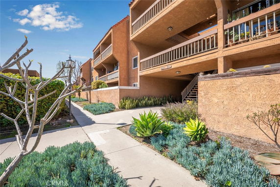 Front view of a multi-story apartment building with balconies.