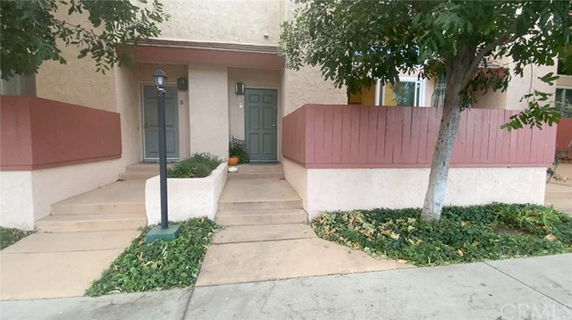 Front view of a multi-unit residential building with two entry doors and small porches.