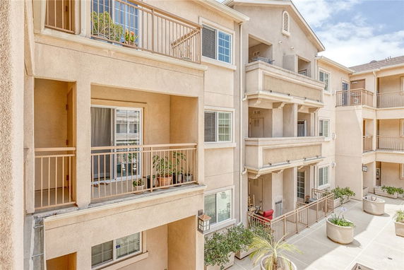 View of an apartment building with multiple balconies and large planters.