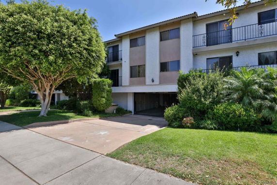 Front view of a multi-story residential building with a gated entrance.