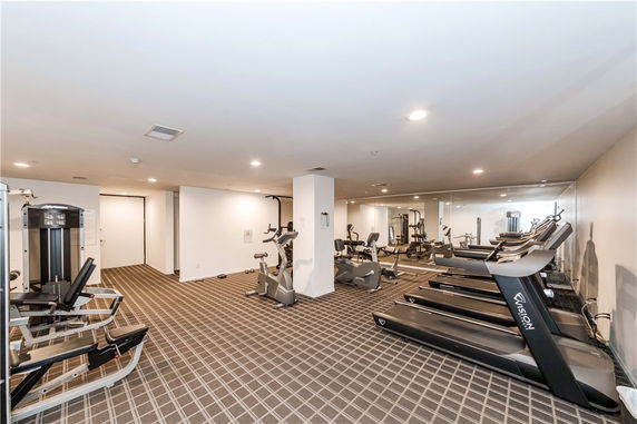 Indoor gym area with various exercise equipment including treadmills and stationary bikes.