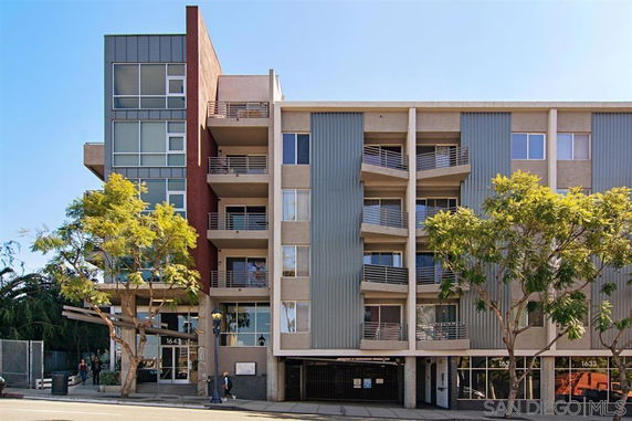 Front view of a multi-story residential building with balconies and a modern facade.