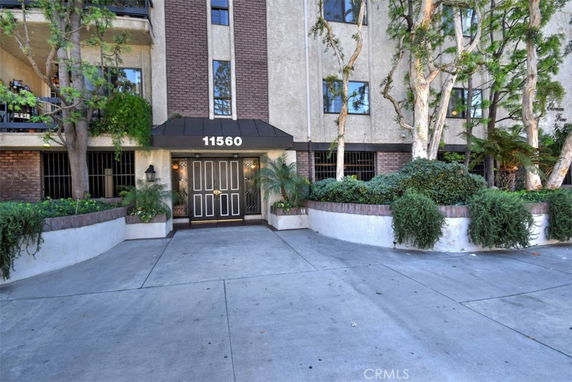 Front view of a multi-story building entrance with a brick and stucco facade.