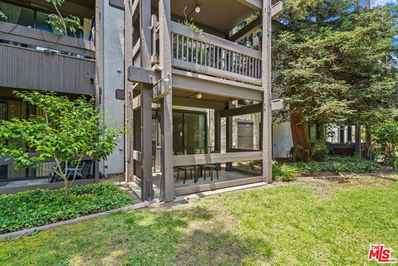 Front view of a multi-story building with balconies and patio area.