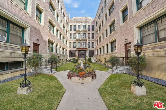 Front view of a multi-story building with a central garden and pathway.