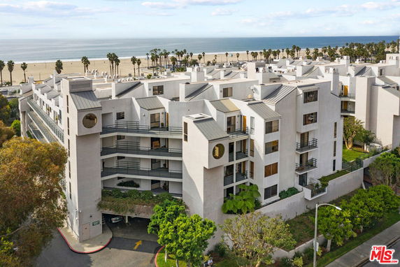 Front view of a multi-story building with modern design located near a beach.