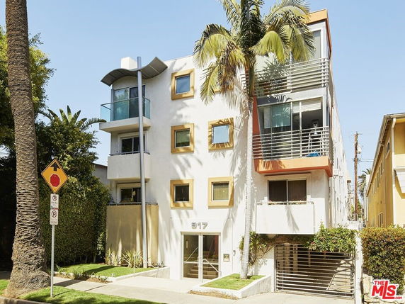 Front view of a multi-story apartment building with balconies.