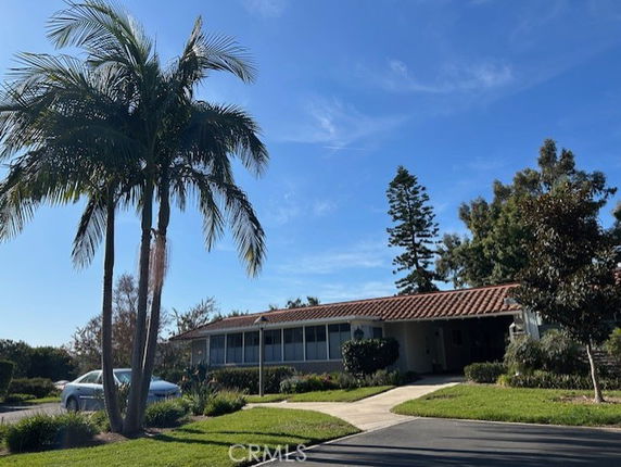 Front view of a single-story house with a tile roof and attached carport.