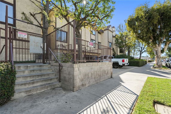 Front view of a multi-story building with exterior staircase and railing.