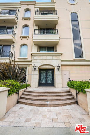 Front view of a multi-story residential building with balconies.