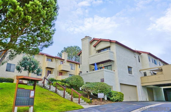 Front view of a multi-story residential building with angled roofs and balconies.