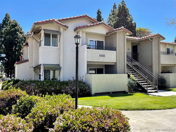 Front view of a two-story building with multiple units and outdoor stairs.