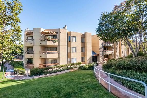 Front view of a multi-story apartment building with balconies.