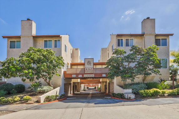 Front view of a multi-story building with an entrance archway and balconies.