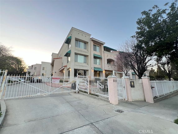 Front view of a multi-story building with gated entrance.