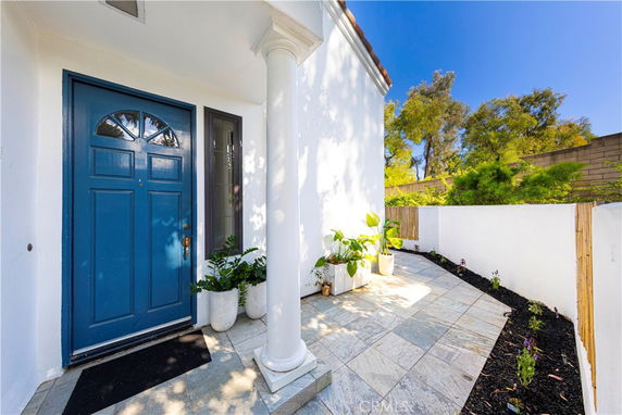 Front view of a house with a blue door and columned entryway.