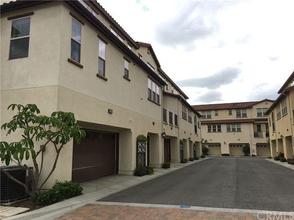 Front view of a multi-story residential building with garages on the ground floor.