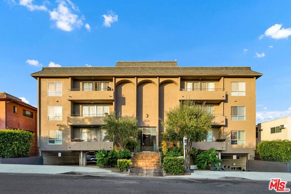 Front view of a multi-story building with balconies and a central entrance.