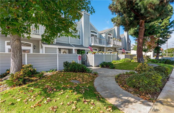 Front view of a row of houses with a pathway and small fences.
