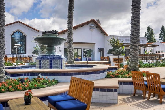Front view of a building with a fountain and outdoor seating area.