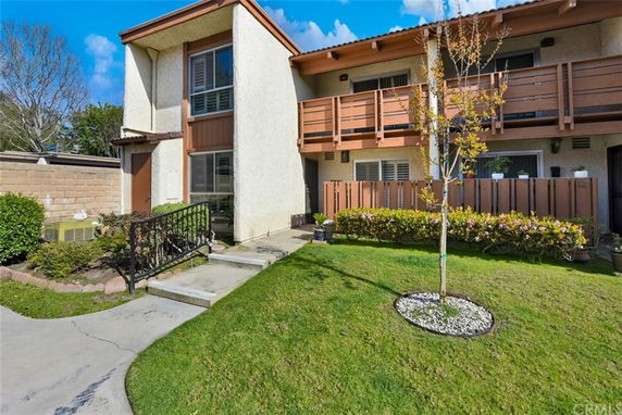 Front view of a house with a balcony and a small garden area.