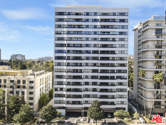 Front view of a high-rise building with multiple floors and large windows.