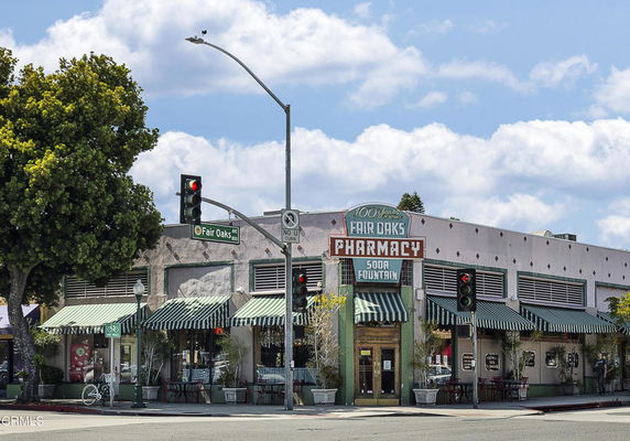 Front view of a commercial building with a pharmacy and soda fountain.