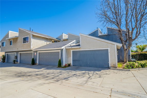 Front view of a two-story residential building with multiple garages.