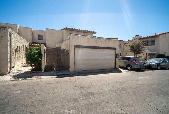 Front view of a house with a garage and gated entrance.