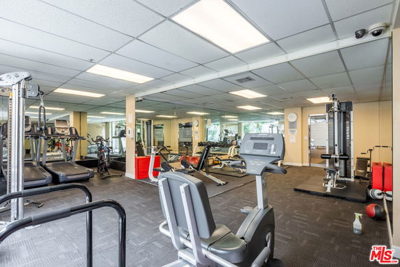 Interior view of a gym with exercise equipment and mirrored walls.