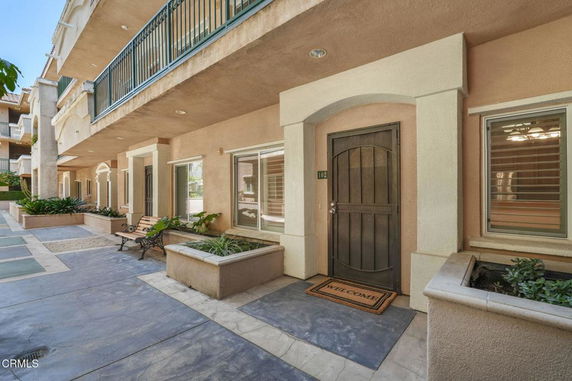 Front view of a multi-story building with a walkway and entrance.