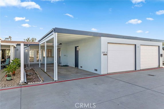 Covered parking area in front of a house with garage