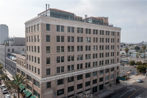 Front view of a multi-story building with numerous windows and a rooftop area.