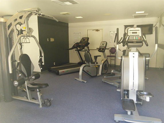 Interior of a gym with exercise equipment including a treadmill, stationary bike, and elliptical.