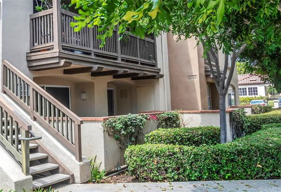 Front view of a multi-level building with an outdoor staircase and balcony.