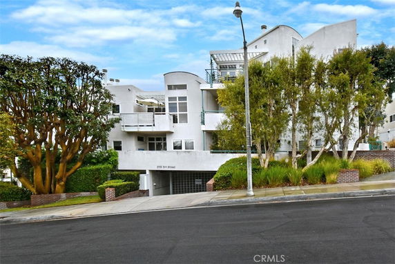 Front view of a multi-story modern apartment building with balconies.