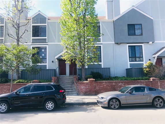Front view of a townhouse with steps leading to two entrance doors.