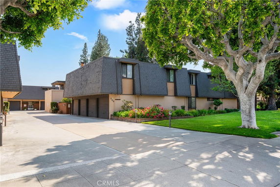 Front view of a two-story house with a unique roof design and garage doors.