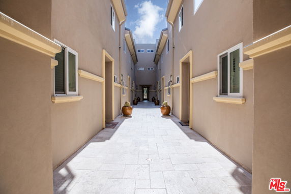 View of a residential building corridor with multiple floors and windows.