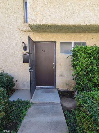 Front view of a building entrance with a door marked with the number 52.