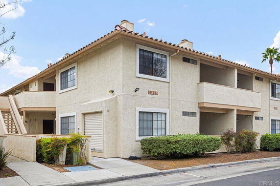 Front view of a two-story apartment building with balconies and attached garage.