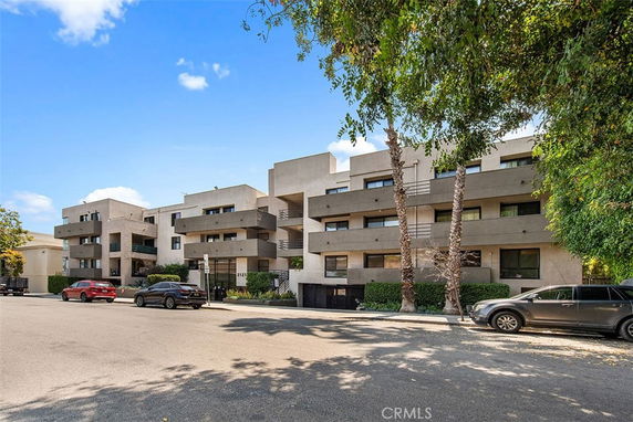 Front view of a modern multi-story apartment building with balconies.
