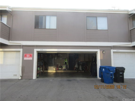 Front view of a multi-story building with a garage in an urban setting.