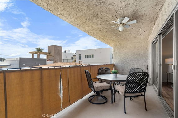 Apartment balcony with outdoor seating overlooking adjacent buildings