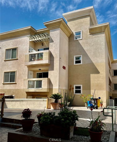 Front view of a multi-story apartment building with balconies and large windows.