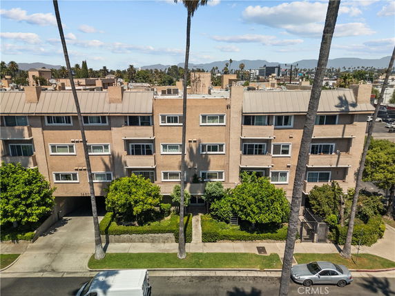 Front view of a multi-story apartment building with a beige exterior.