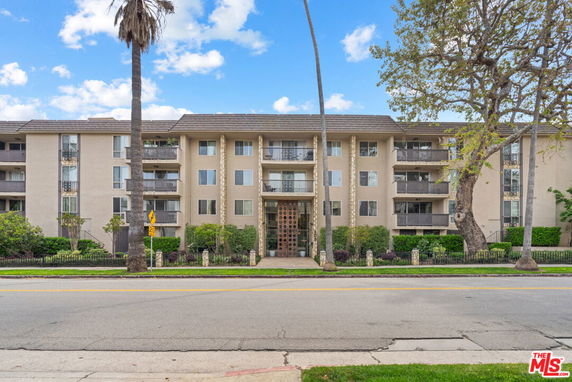 Front view of a multi-story apartment building with balconies.